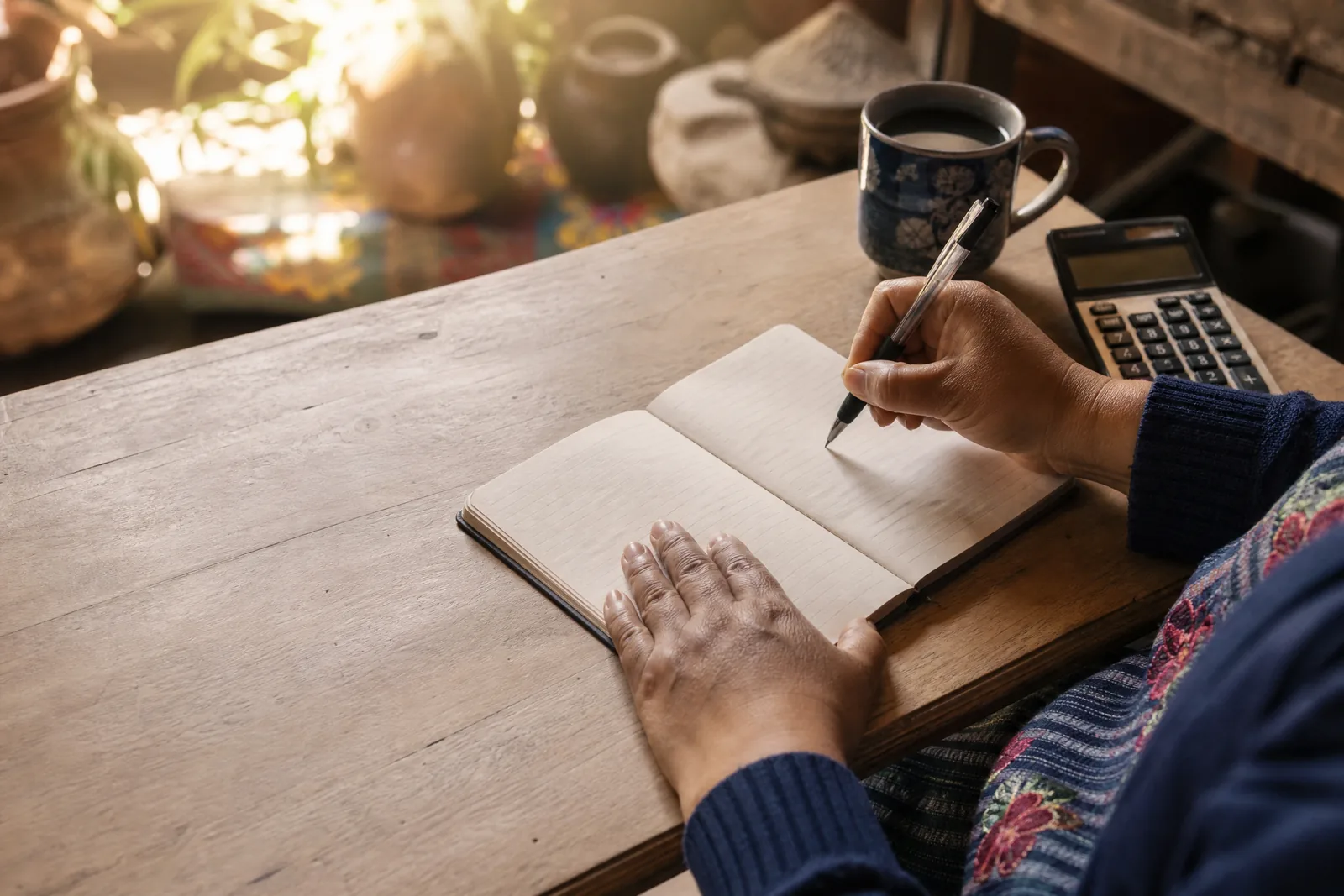 Escribiendo el presupuesto familiar en un cuaderno