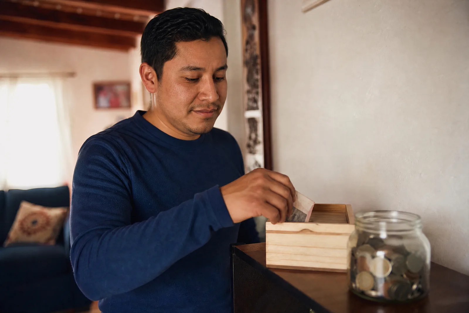 Guardando dinero en una caja de madera en casa