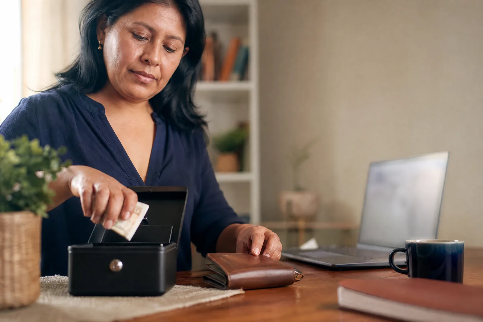 Emprendedora guatemalteca separando dinero del negocio y dinero personal en un escritorio