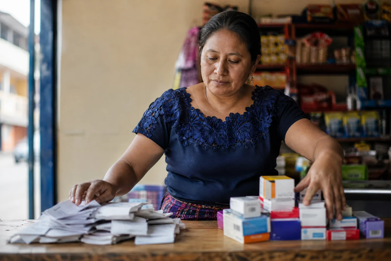 Dueña de negocio separando recibos y productos para distinguir costos fijos y variables